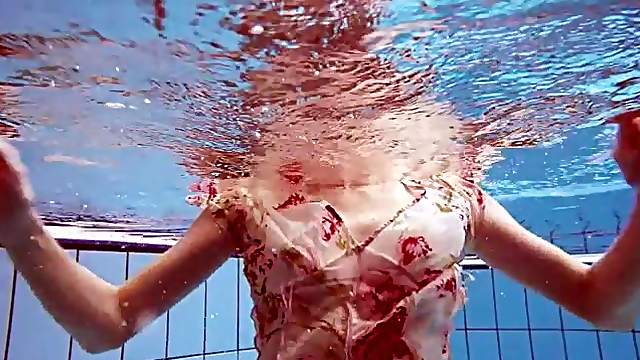 Slender teen goes for a swim in her pretty dress