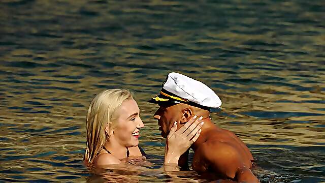 A girl with big boobs is having fun on the beach with her boyfriend.
